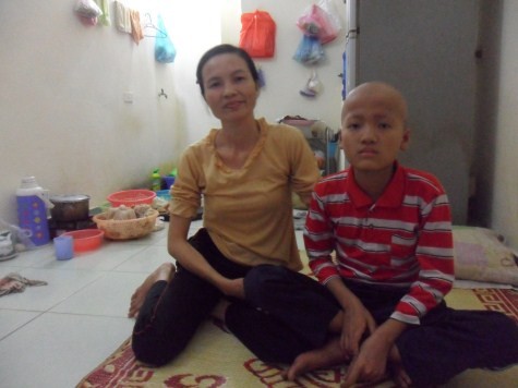 Cháu Nguyễn Văn Cường ngồi nép bên mẹ là chị Đặng Thị Thơm